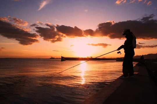 海に沈む夕日。いつアタリがやってくるのだろうと待つ釣り人。毎夜繰り返される心ときめく瞬間です